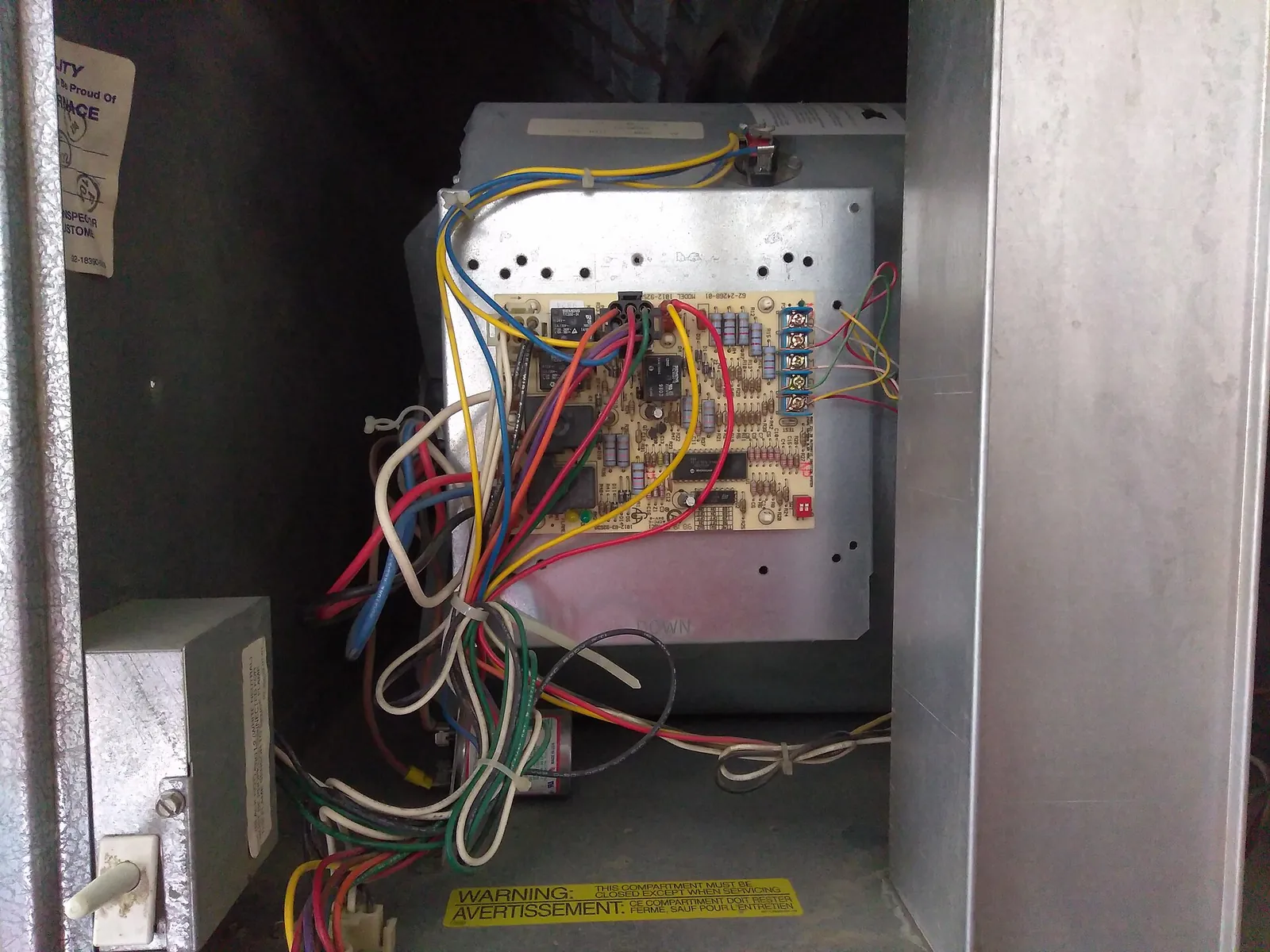Open furnace cabinet showing the control board and low-voltage thermostat wiring
